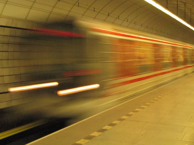 A subway train moving quickly through a tunnel, creating a motion blur effect
