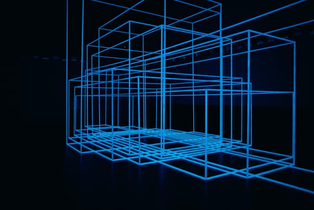 A series of glowing blue wireframe geometric shapes arranged in a three-dimensional space against a dark background