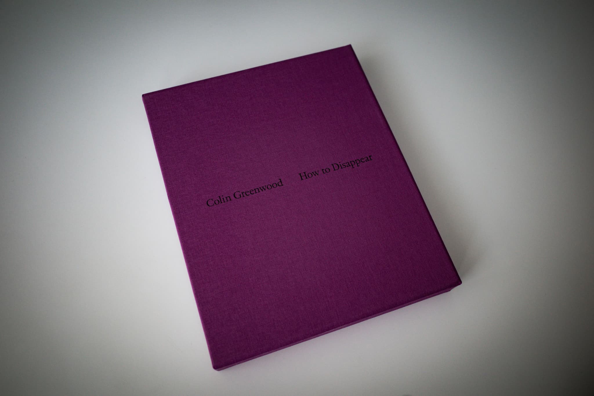 A purple book with text on the cover, placed on a light surface