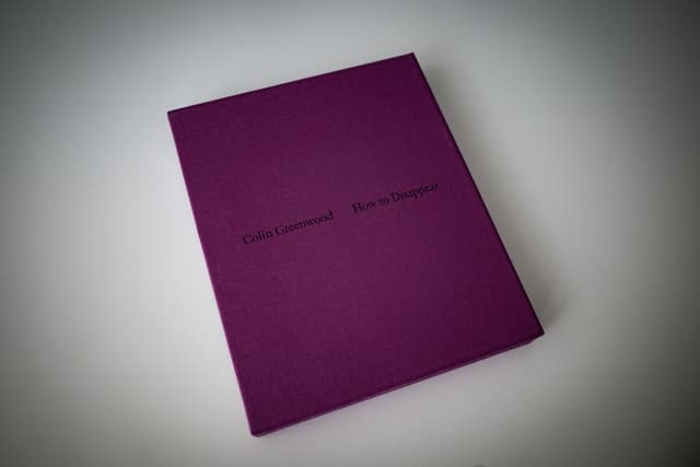 A purple book with text on the cover, placed on a light surface